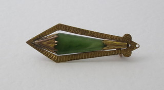 A gold brooch set a green hardstone
