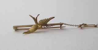 A gold bar brooch in the form of a diving dove