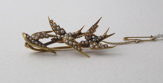 A gold bar brooch in the form of 3 doves set demi-pearls