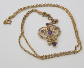 A lady's gold pendant set amethyst and diamonds hung on a fine gold chain