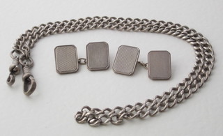 A pair of silver cufflinks and a silver curb link watch chain