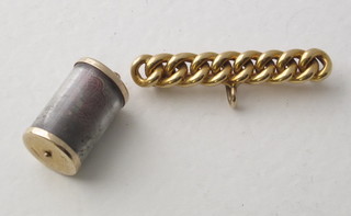 A gilt metal rope bar brooch and a gilt metal charm set a 10  shilling note