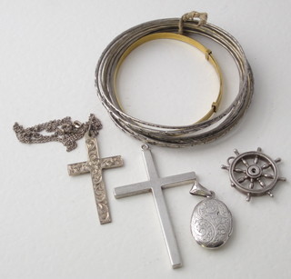 A silver cross, a silver locket, a pendant in the form of a ships  wheel, a silver bracelet and a gilt metal bracelet