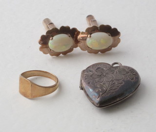 A pair of "gold" cufflinks set opals, a gold signet ring and a silver heart shaped locket