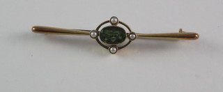 A gold bar brooch set oval tourmaline supported by pearls