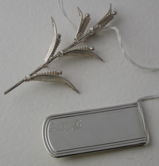 A silver filigree brooch and a money clip
