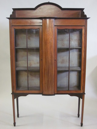 An Edwardian inlaid mahogany display cabinet with three-quarter gallery, fitted shelves and enclosed by glazed panelled doors,  raised on square tapering supports 43"