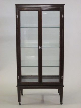 A mahogany pedestal glazed shop display cabinet, fitted shelves and raised on square supports 28"