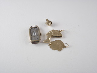 A gold cased wristwatch and 3 gold charms