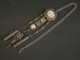 A white metal chatelaine hung a propelling pencil,  perfume bottle holder and needle case