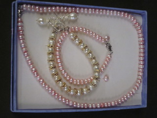 A rope of pink freshwater pearls together with matching bracelet  and earrings, and 1 other bracelet and earrings