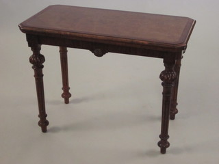 A Victorian lozenge shaped figured walnut card table raised on turned and fluted supports 36"