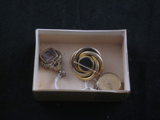 A gilt metal chain medallion in the form of a roulette wheel, a gilt metal seal and a gilt metal bracelet