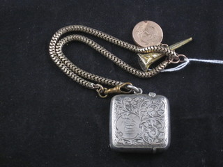 A gilt metal chain hung a gold locket and a silver vesta case