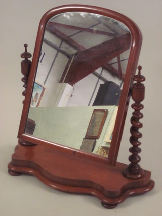 A Victorian arch shaped dressing table mirror contained in a  mahogany frame supported by a spiral turned column, raised on a  shaped base 27"