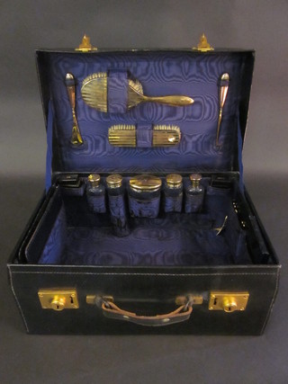 A blue vanity case containing silver backed hair brush, clothes brush, sugar bowl and button hook together with 5 various glass  bottles all with silver lids, Birmingham 1918