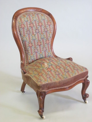A Victorian mahogany show frame nursing chair upholstered in  tapestry material and raised on cabriole supports