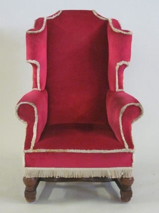 An oak framed Georgian style winged armchair upholstered in  red material