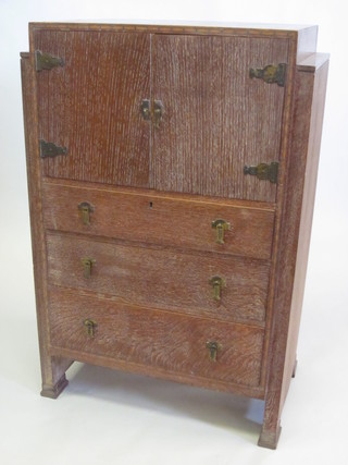 A limed oak tall boy fitted cupboards enclosed by panelled doors  above 3 long drawers 30"