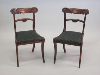 A pair of William IV mahogany bar back dining chairs with  carved mid rails and upholstered drop in seats, raised on sabre  supports
