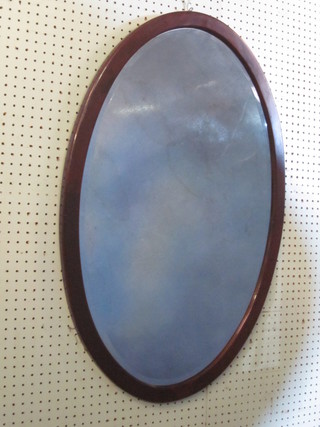 An oval bevelled plate wall mirror contained in a mahogany  frame 34"