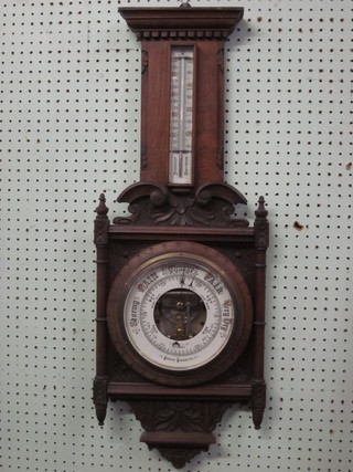 An Edwardian aneroid barometer and thermometer contained in a  carved walnut case by J W Ray & Co of Liverpool