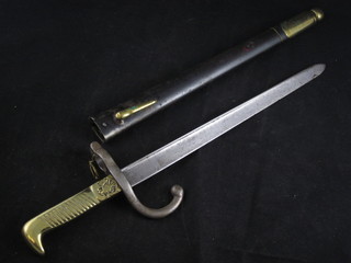 A small chassepot type bayonet with 11" blade and brass grip  with coat of arms, contained in a steel scabbard