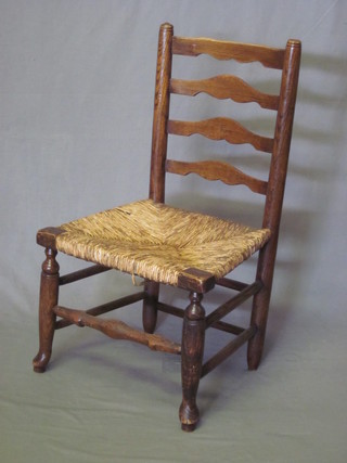 An 18th/19th Century elm ladder back dining chair with woven  rush seat