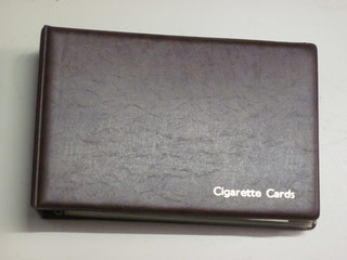 A brown loose leaf album containing cigarette cards