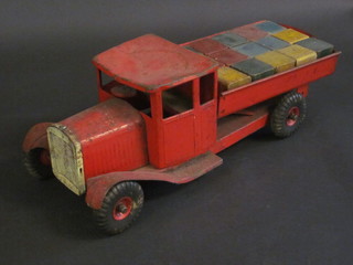 A childs tin plate model of a tip-up truck containing a collection of bricks