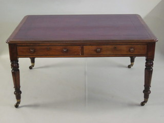 A handsome William IV mahogany library table with inset tooled leather writing surface, fitted 4 long drawers and raised on turned  and reeded supports ending in brass caps and castors 59"