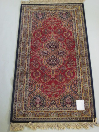 A red and blue ground machine made Persian style rug 70" x 36"