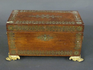 A Victorian rosewood and brass inlaid twin compartment tea  caddy, the interior fitted 2 caddies and complete with cut glass  mixing/sugar bowl, having brass ring handles to the side and  raised on brass paw feet 13 1/2"