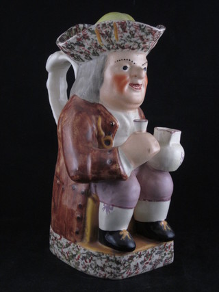 A 19th Century Staffordshire Toby jug in the form of a seated gentleman with jug and glass complete with lid, f and r, 10"