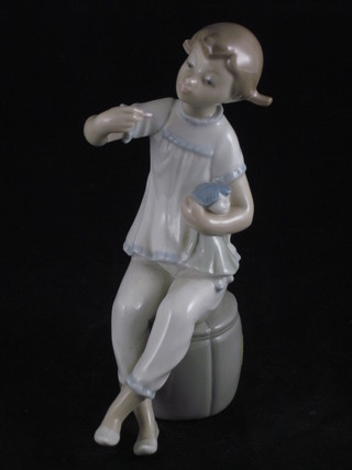 A Lladro figure of a seated girl with doll 7"
