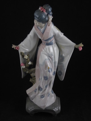 A Lladro figure of a standing Geisha girl raised on a stand 10", hand f and r,