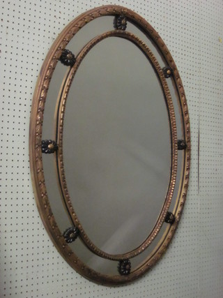 A Georgian style oval bevelled plate mirror contained in a decorative gilt frame 38"