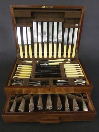 A canteen of silver plated flatware contained in a walnut canteen  box