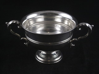 A circular silver twin handled trophy cup, London 1911, raised  on a circular spreading foot, 8 ozs