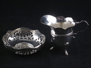 A silver cream jug, Chester, marks rubbed, together with a circular pierced silver bowl, Birmingham 1944, 2 1/2 ozs