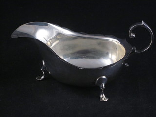A Georgian style silver cream jug with cut border and C scroll handle, raised on 3 hoof feet, Chester 1924, 3 1/2 ozs