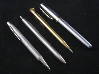 A Schaefer fountain pen contained in a steel and gilt case, a Usus  pen and propelling pencil in a silver coloured case and a gilt  cased propelling pencil