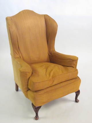 A Georgian style mahogany framed winged armchair raised on cabriole supports  ILLUSTRATED