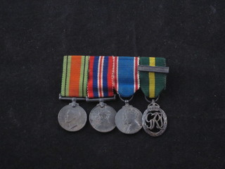 A group of 4 miniatures comprising Defence and War medal,  George VI Coronation medal and George VI issue territorial  decoration