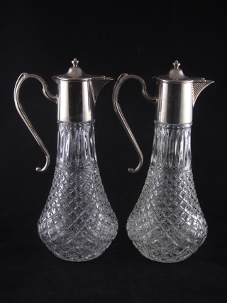 A pair of moulded glass claret jugs with silver plated mounts