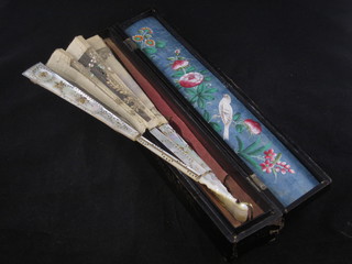 An Oriental mother of pearl fan with carved sticks, 1 f and r, contained in a lacquered box