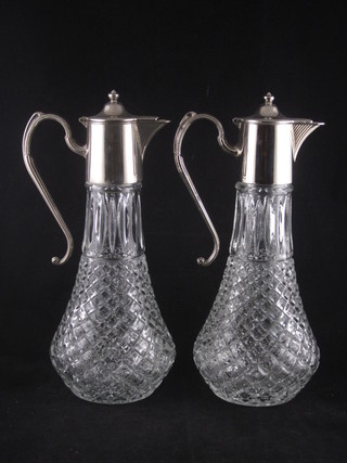 A pair of glass claret jugs with silver plated mounts