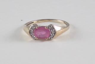A gold dress ring an oval cut pink sapphire surrounded by  diamonds