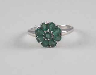 A lady's silver dress ring set green stones