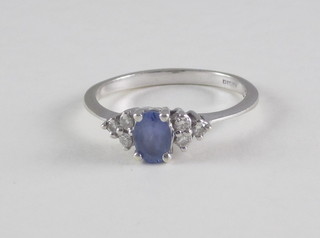 A 9ct white gold dress ring set a tanzanite and supported by  diamonds